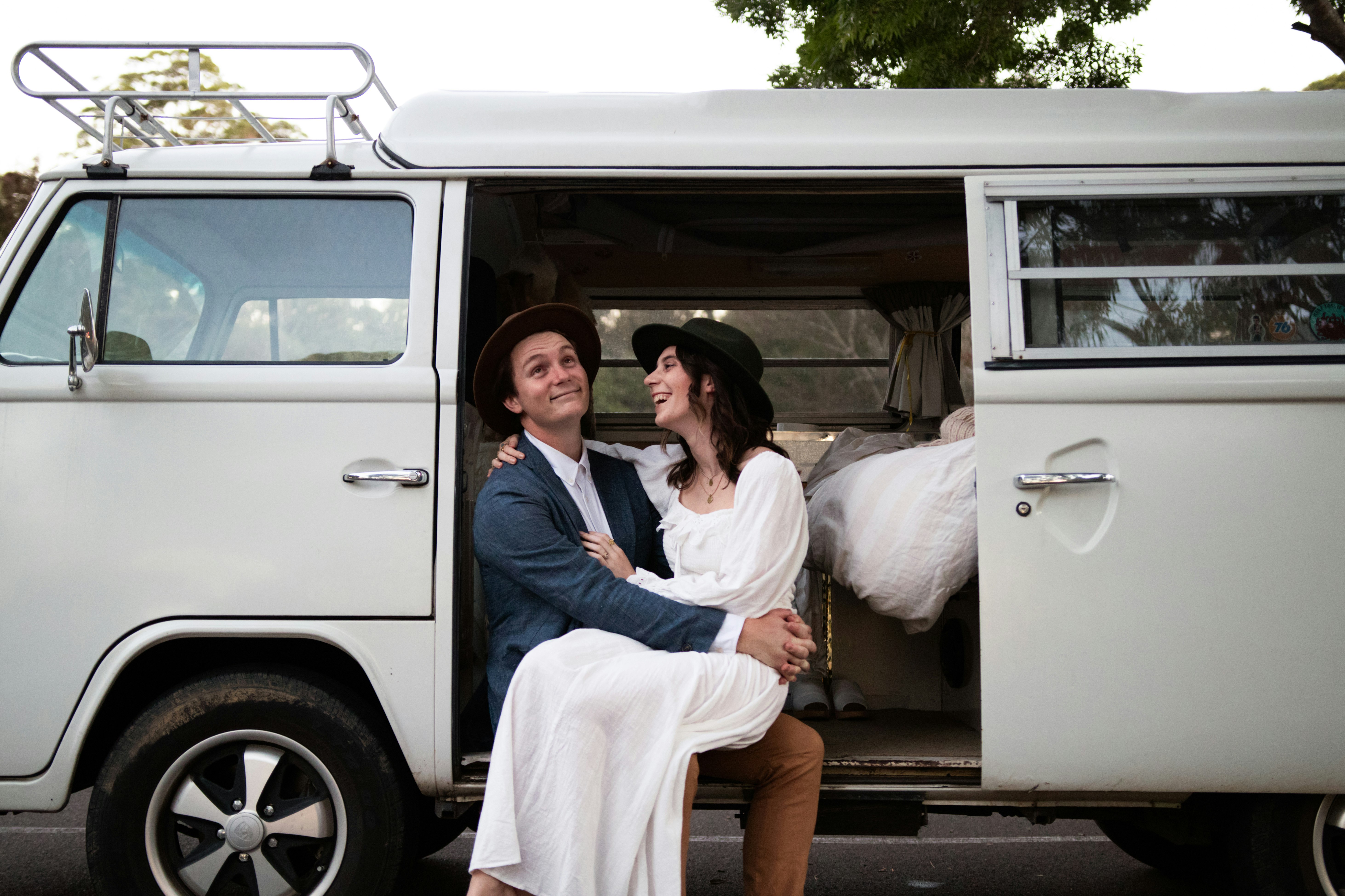 man in blue dress shirt sitting on white van